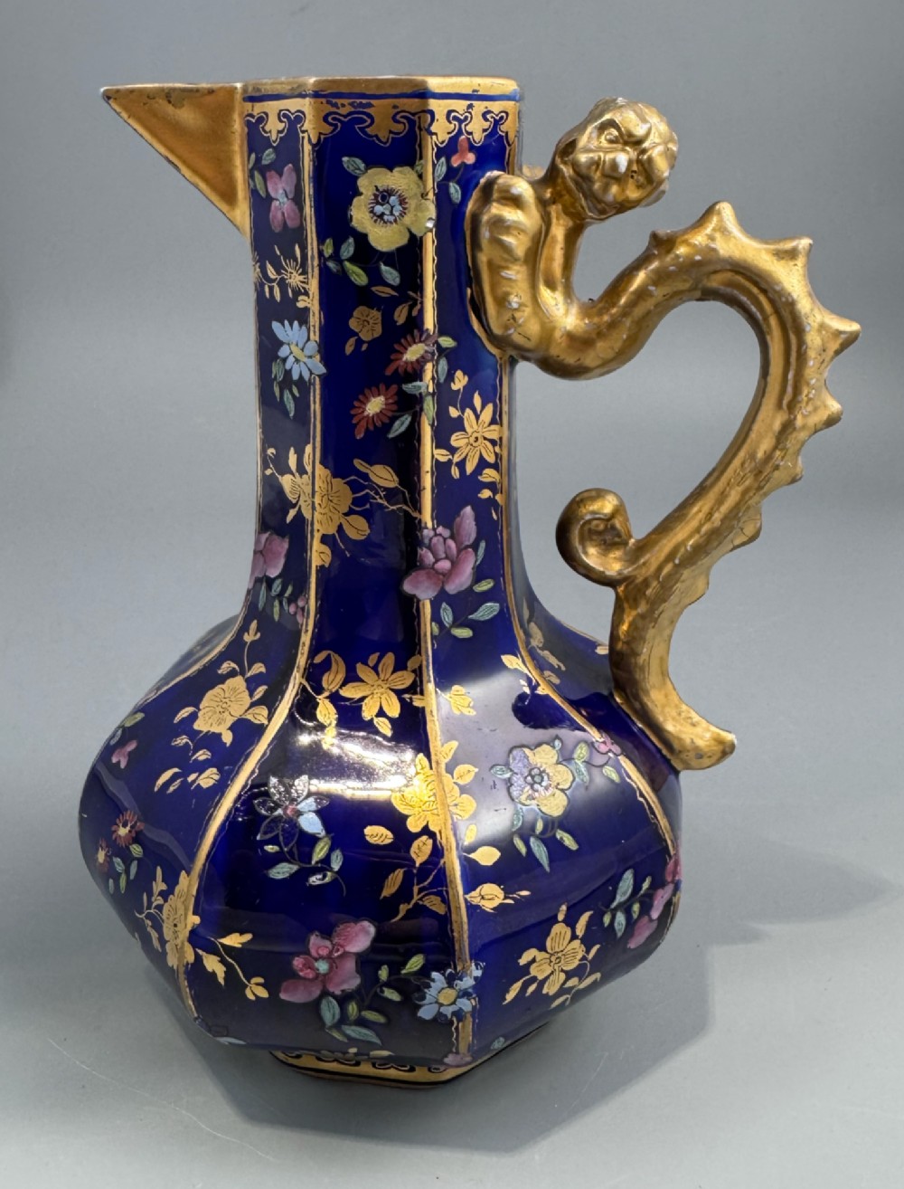 An octagonal cobalt blue ironstone ewer decorated with hand-painted Chinoiserie floral patterns and a gilded grotesque animal form handle. View III