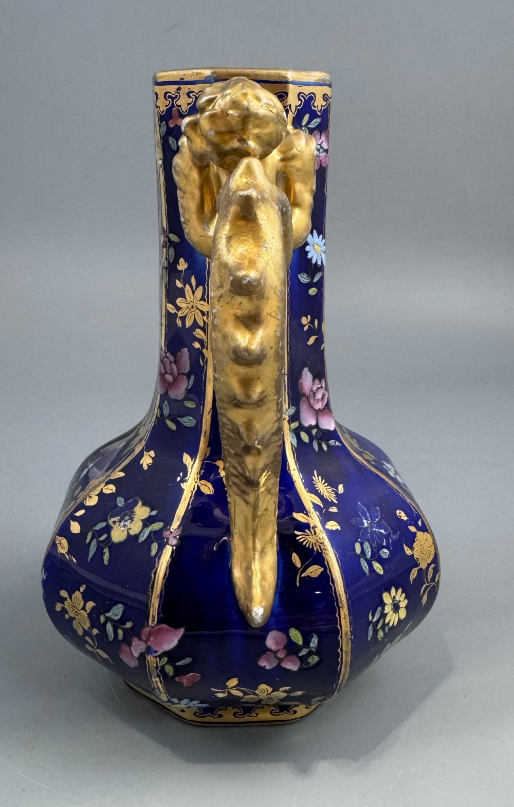 An octagonal cobalt blue ironstone ewer decorated with hand-painted Chinoiserie floral patterns and a gilded grotesque animal form handle. View IV