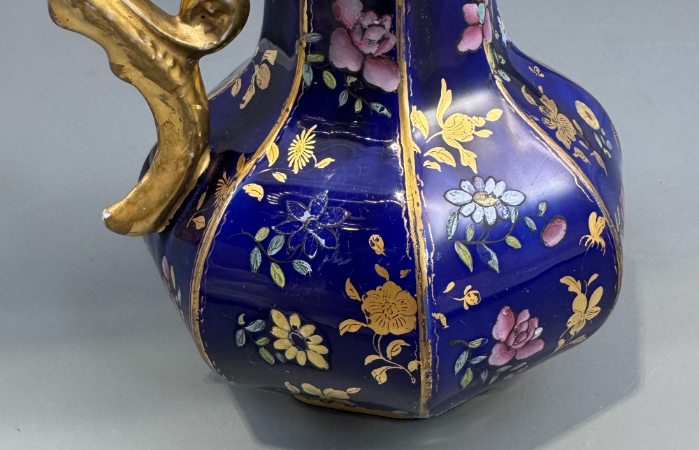 An octagonal cobalt blue ironstone ewer decorated with hand-painted Chinoiserie floral patterns and a gilded grotesque animal form handle. View V