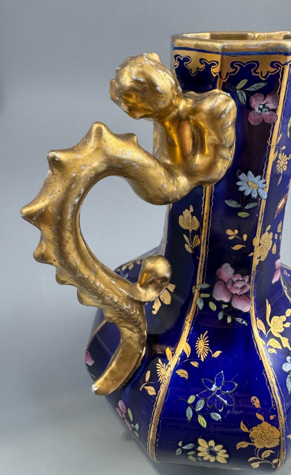 An octagonal cobalt blue ironstone ewer decorated with hand-painted Chinoiserie floral patterns and a gilded grotesque animal form handle. View VII