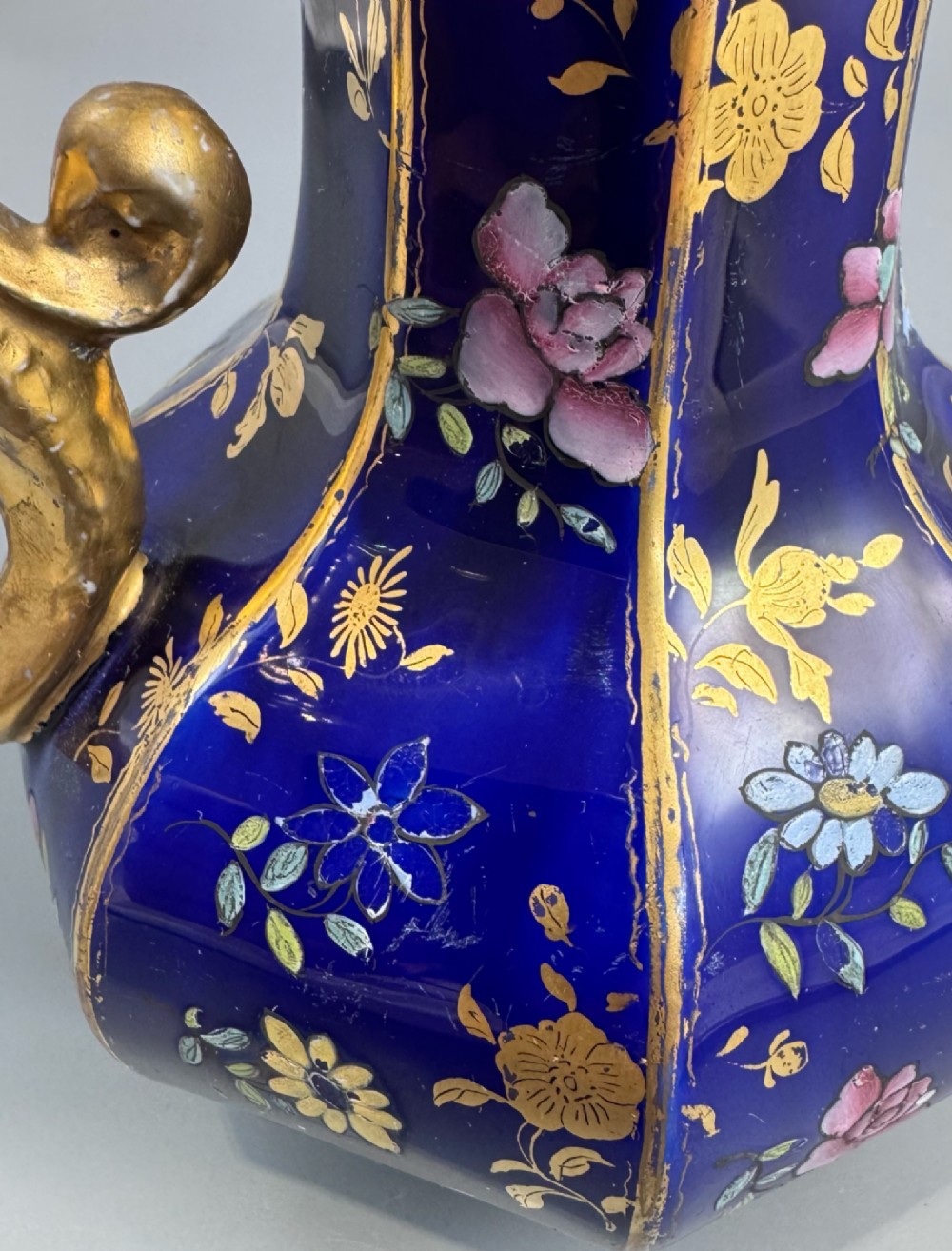 An octagonal cobalt blue ironstone ewer decorated with hand-painted Chinoiserie floral patterns and a gilded grotesque animal form handle. View VIII