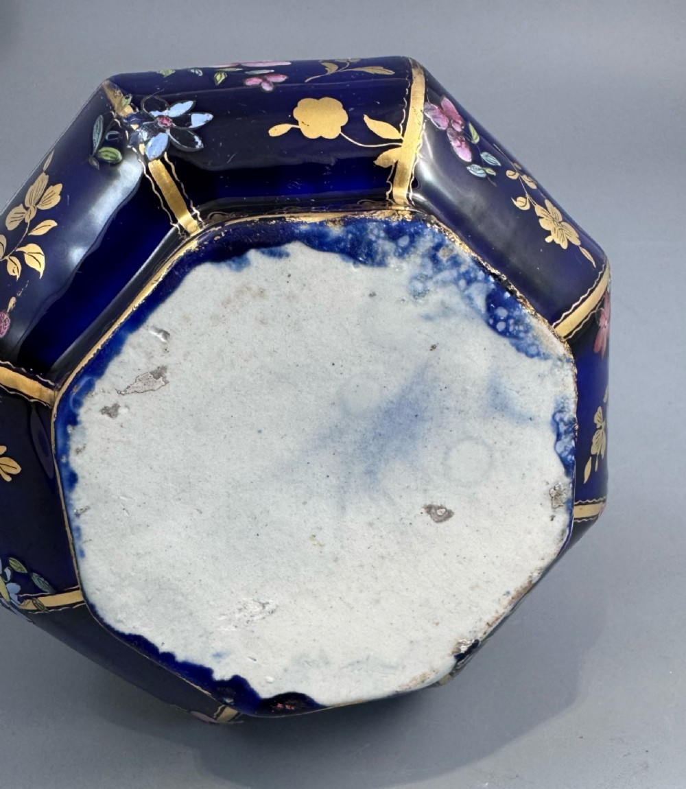 An octagonal cobalt blue ironstone ewer decorated with hand-painted Chinoiserie floral patterns and a gilded grotesque animal form handle. View IX