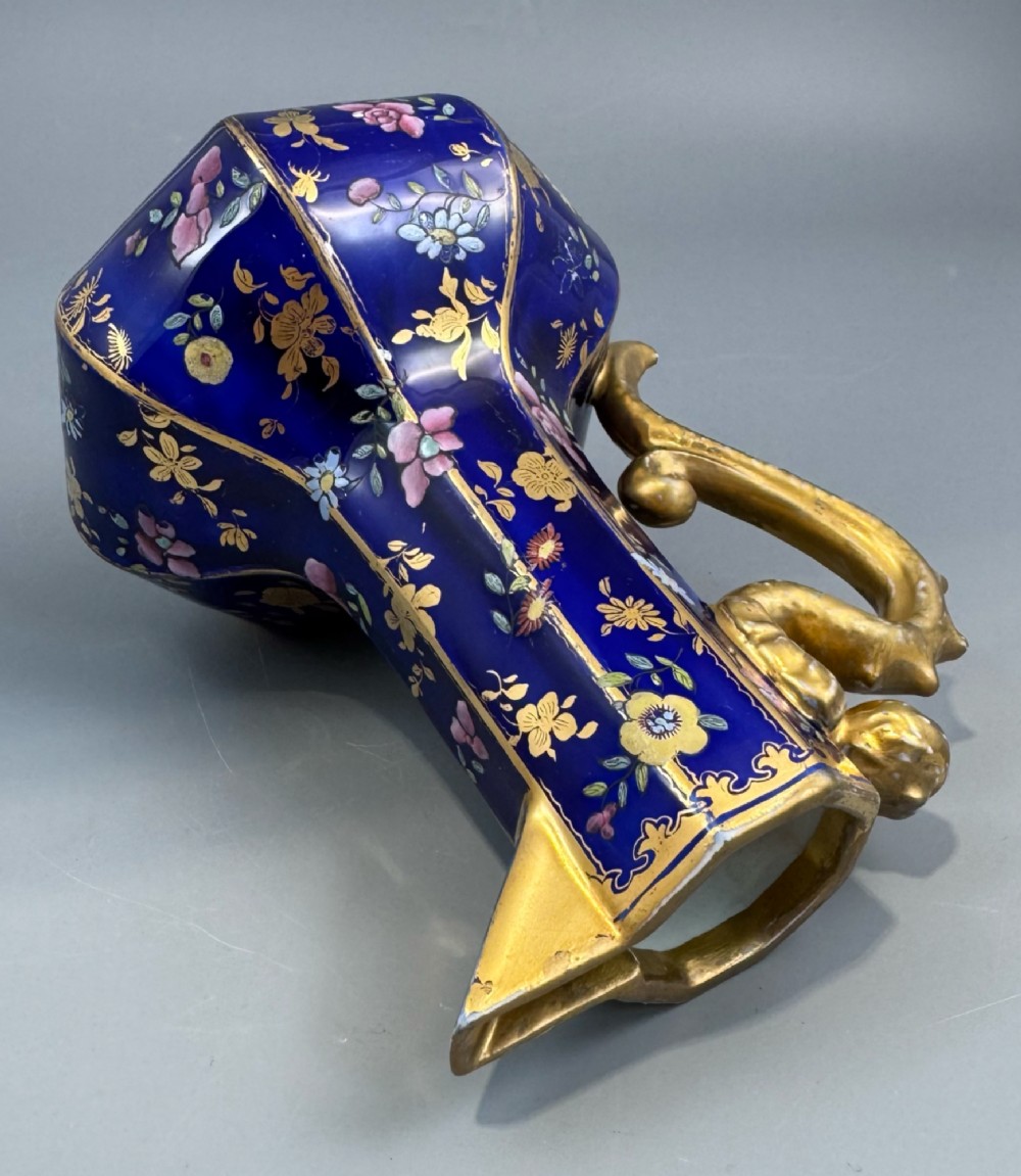 An octagonal cobalt blue ironstone ewer decorated with hand-painted Chinoiserie floral patterns and a gilded grotesque animal form handle. View X
