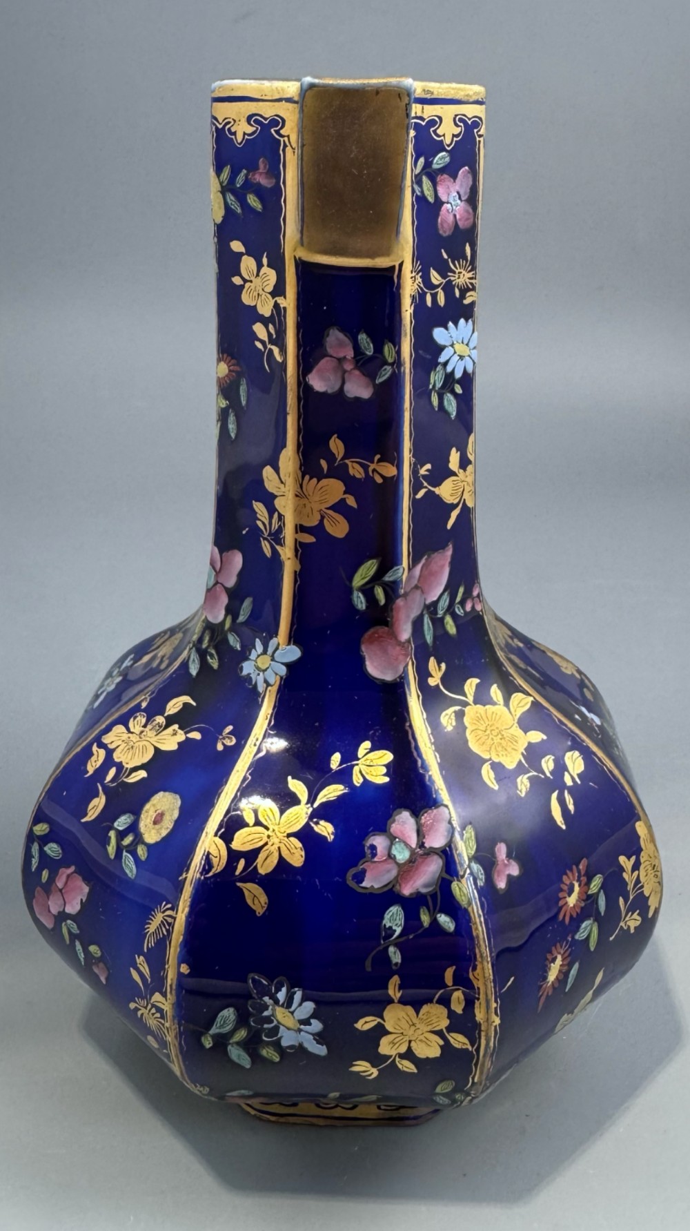 An octagonal cobalt blue ironstone ewer decorated with hand-painted Chinoiserie floral patterns and a gilded grotesque animal form handle. View XI