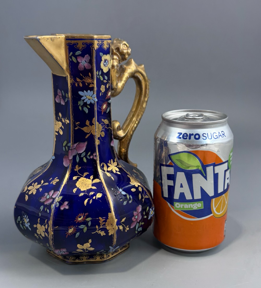 An octagonal cobalt blue ironstone ewer decorated with hand-painted Chinoiserie floral patterns and a gilded grotesque animal form handle. View XII