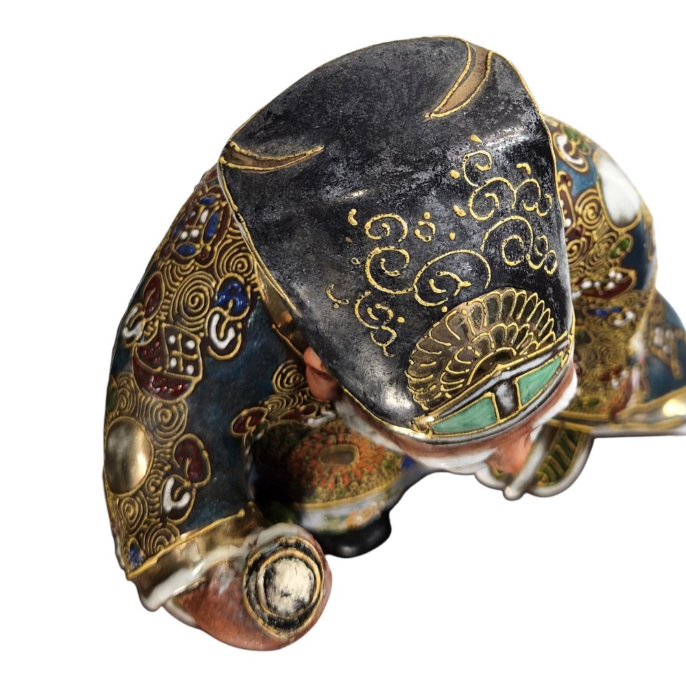 A Japanese Kutani porcelain figurine depicting Jurojin with a long white beard holding a staff, decorated in polychrome overglaze enamels and gold details. View VII