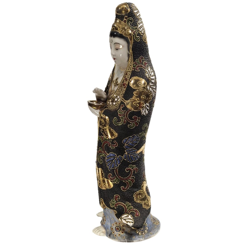 A standing Japanese Kutani porcelain figurine of Kannon with detailed black and gold enamelled robes and a white glazed face. View II
