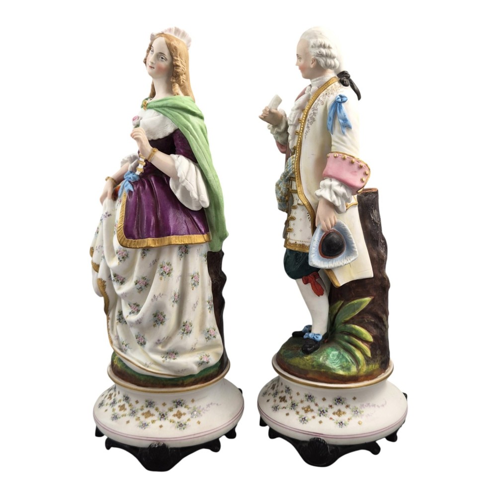 A pair of French biscuit porcelain figures depicting a male and female figure in 18th-century court costume with polychrome enamelled details. View II