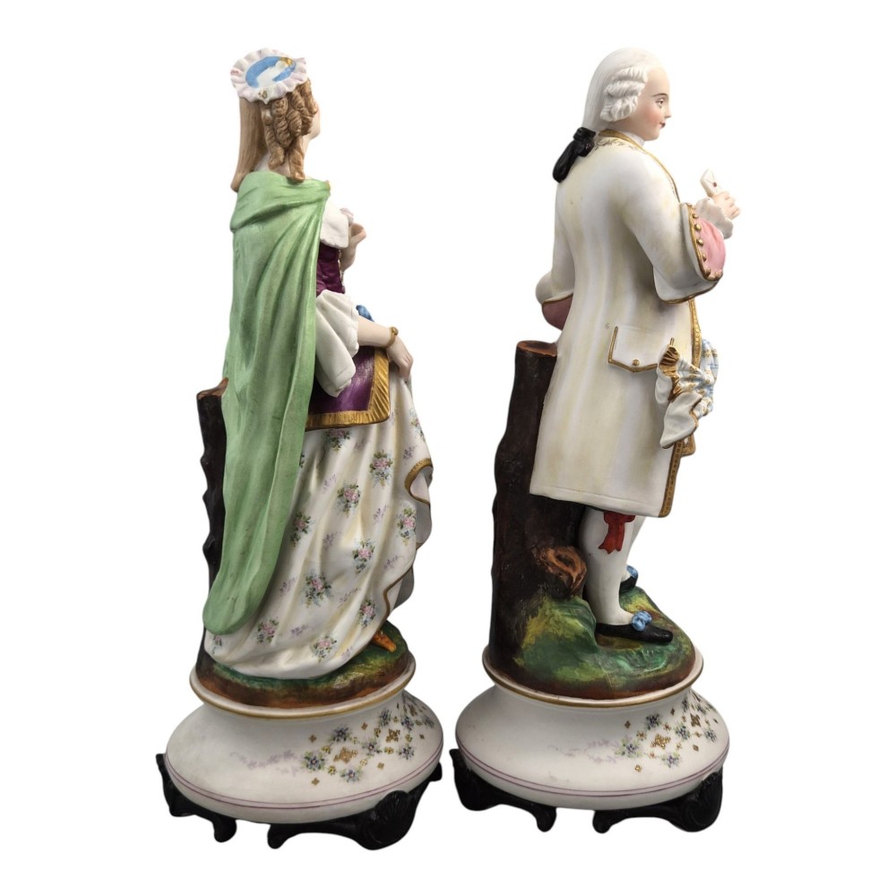 A pair of French biscuit porcelain figures depicting a male and female figure in 18th-century court costume with polychrome enamelled details. View IV