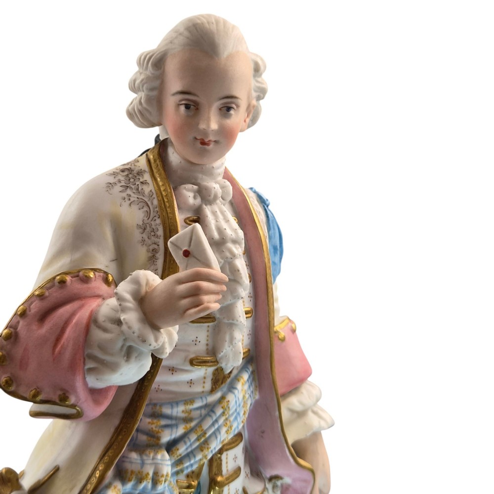 A pair of French biscuit porcelain figures depicting a male and female figure in 18th-century court costume with polychrome enamelled details. View X
