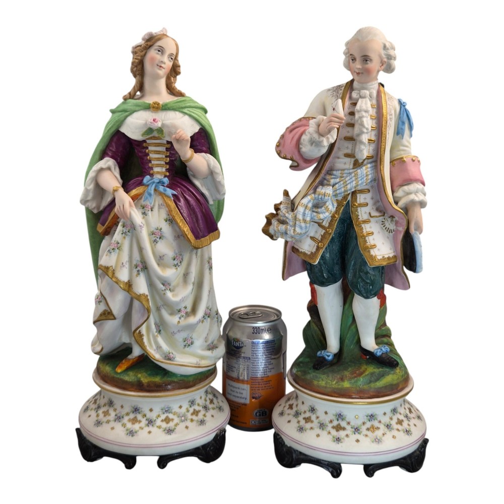 A pair of French biscuit porcelain figures depicting a male and female figure in 18th-century court costume with polychrome enamelled details. View XV