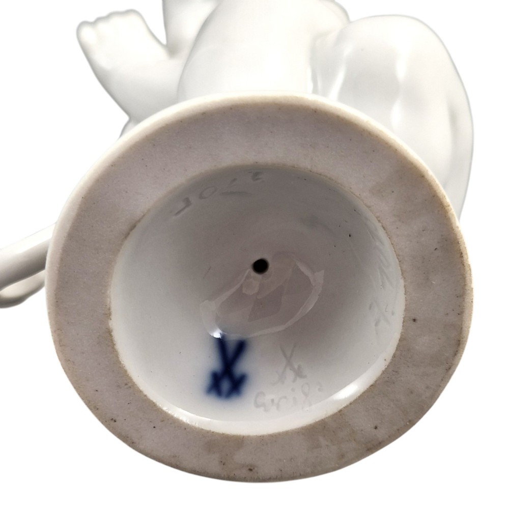 A glazed white porcelain figurine depicting a crouching winged cherub holding a curved bow on a circular base. View VIII