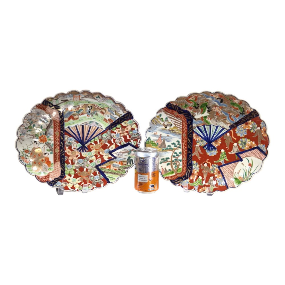 A pair of round antique Japanese Arita Imari porcelain charger plates featuring scalloped edges, fan motifs, landscape scenes, and iron red, cobalt blue, and green enamels. View II