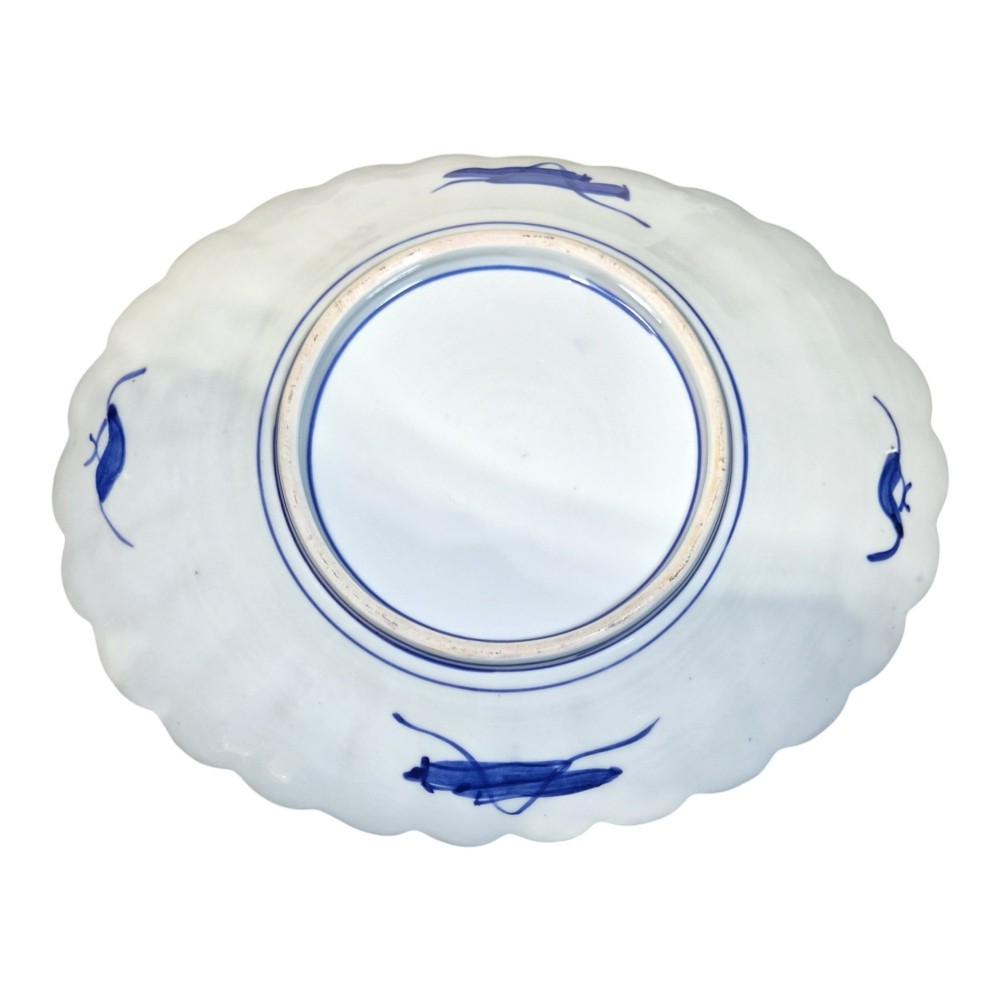 A pair of round antique Japanese Arita Imari porcelain charger plates featuring scalloped edges, fan motifs, landscape scenes, and iron red, cobalt blue, and green enamels. View VII