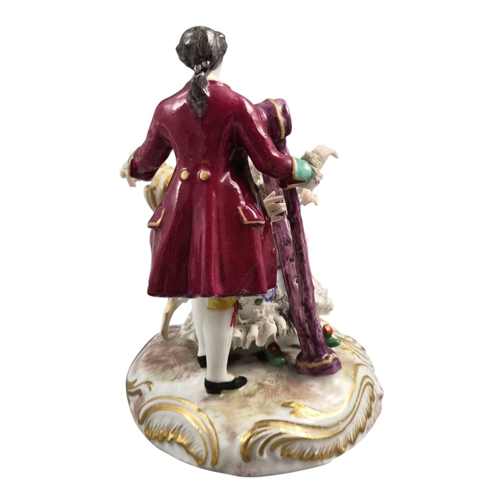 A 19th-century Paris porcelain figural group depicting a man standing behind a seated woman playing a harp, featuring porcelain lace trim and gold scrollwork. View V