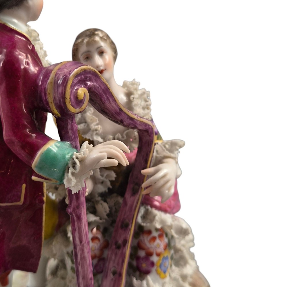 A 19th-century Paris porcelain figural group depicting a man standing behind a seated woman playing a harp, featuring porcelain lace trim and gold scrollwork. View VIII
