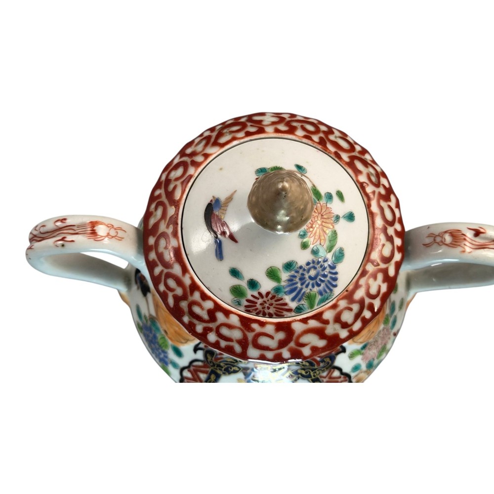 A covered Japanese Imari porcelain sugar bowl featuring double side handles, a pointed gilded finial, and hand-painted samurai and floral motifs in red, blue, green, and gold enamels. View VII