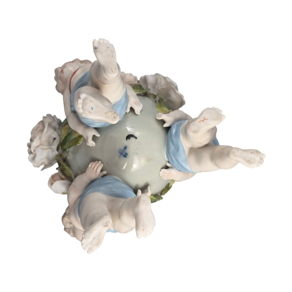 A German Sitzendorf porcelain egg-shaped vase featuring applied green leaves, pale pink roses, and three cherub figures supporting the base. View VIII