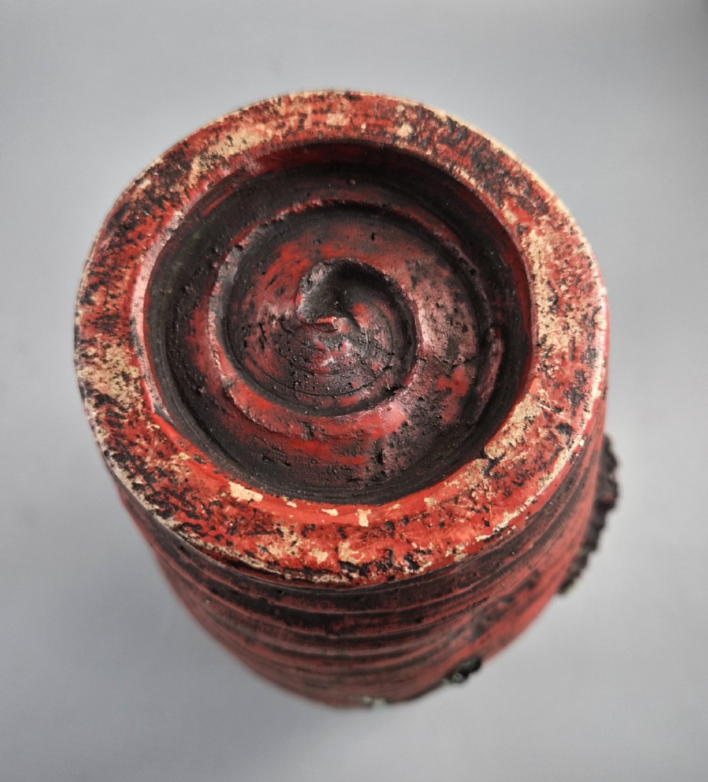 A Japanese Sumida Gawa stoneware vase featuring high-relief sculptures of a stag, waterfall, and tree against a ribbed dark red base with a green drip glaze top rim. View XI