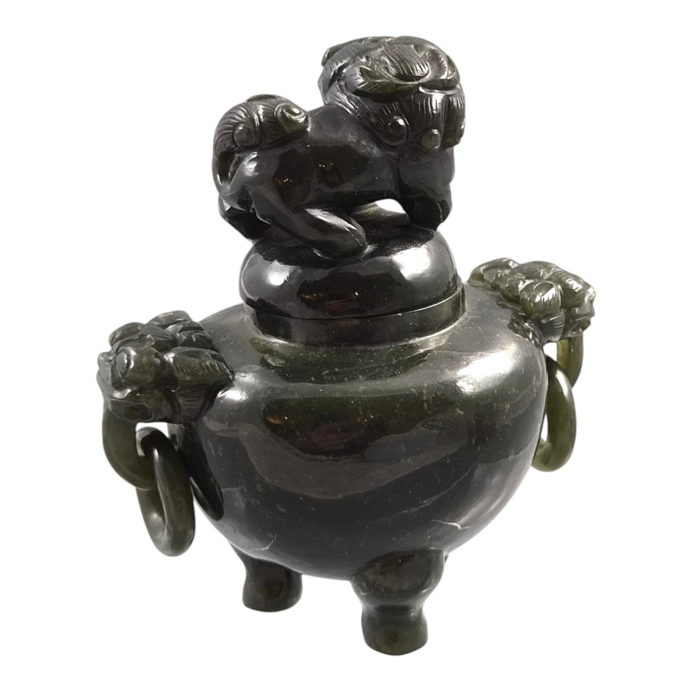 A hand-carved dark green jade tripod censer featuring a foo dog lid finial and lion mask handles with carved loose rings. View V