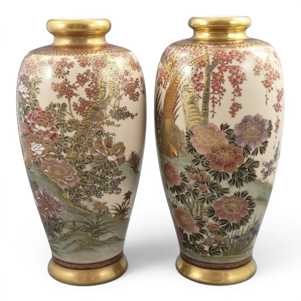A pair of baluster-shaped Japanese Satsuma ceramic vases featuring crackle glaze, gilded necks, and detailed hand-painted floral and bird scenes.