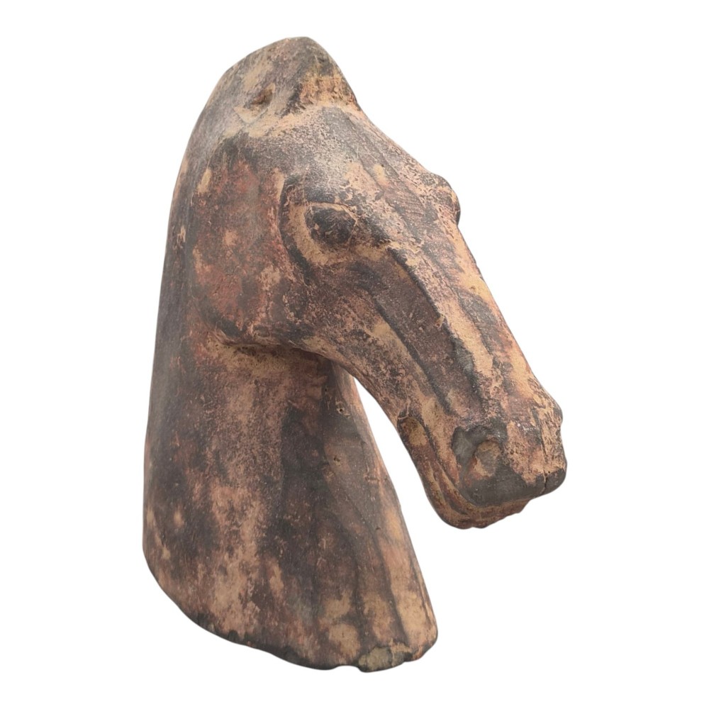 A painted terracotta sculpture depicting the profile of a horse head with earthy red and dark charcoal surface pigments. View II
