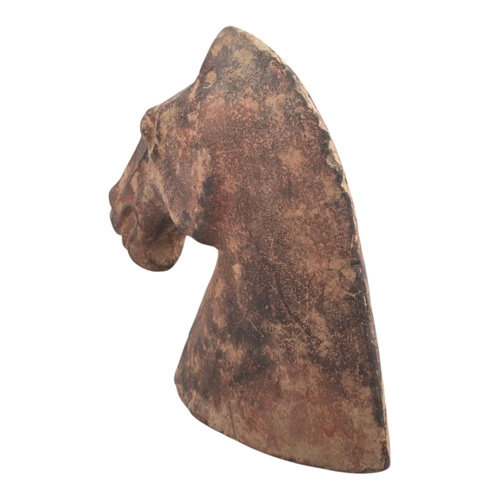 A painted terracotta sculpture depicting the profile of a horse head with earthy red and dark charcoal surface pigments. View VI