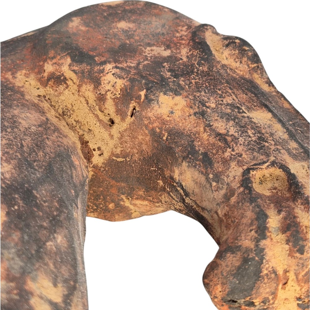 A painted terracotta sculpture depicting the profile of a horse head with earthy red and dark charcoal surface pigments. View XII
