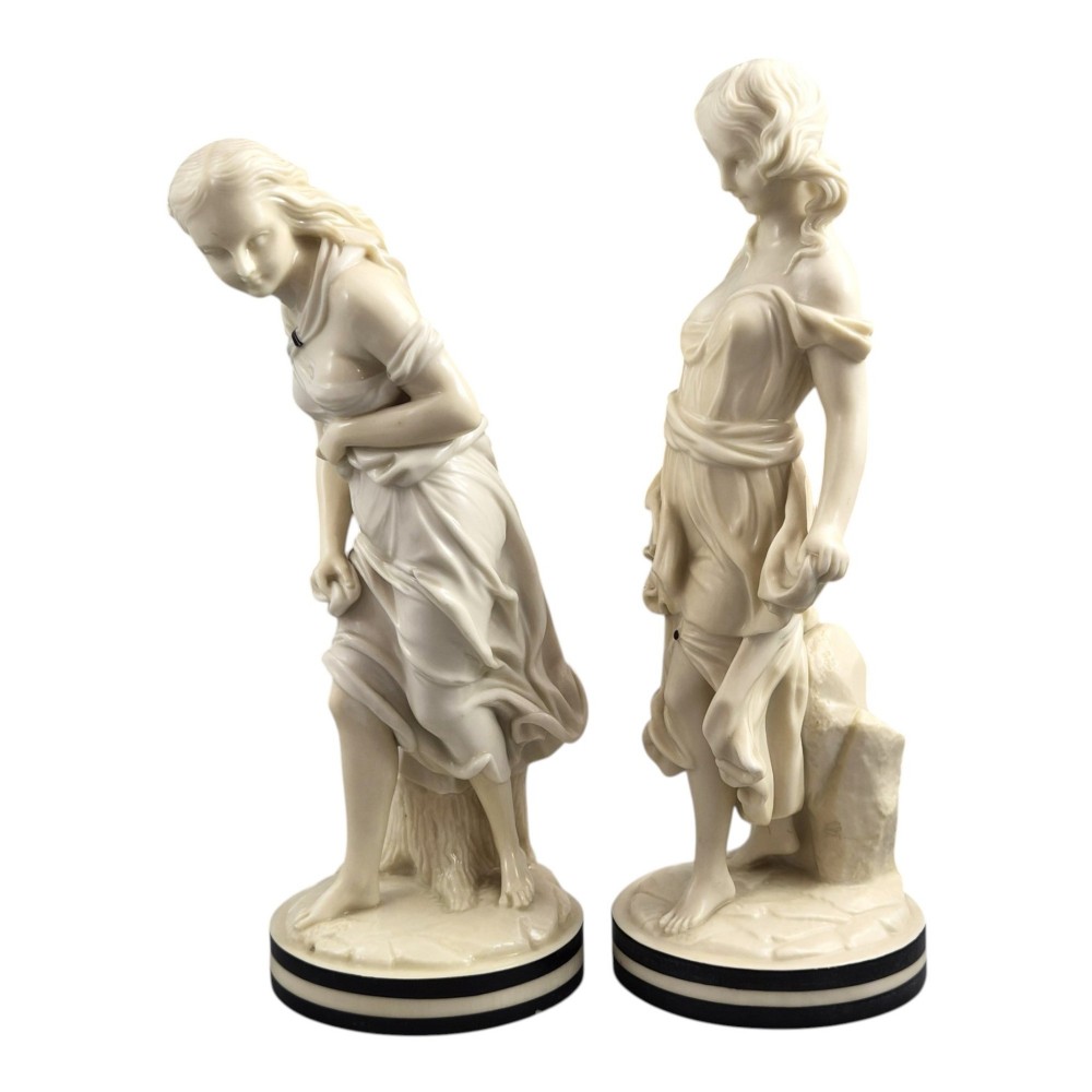 A pair of Victorian cream-glazed porcelain figures depicting classical female forms with flowing drapery set on circular bases. View II
