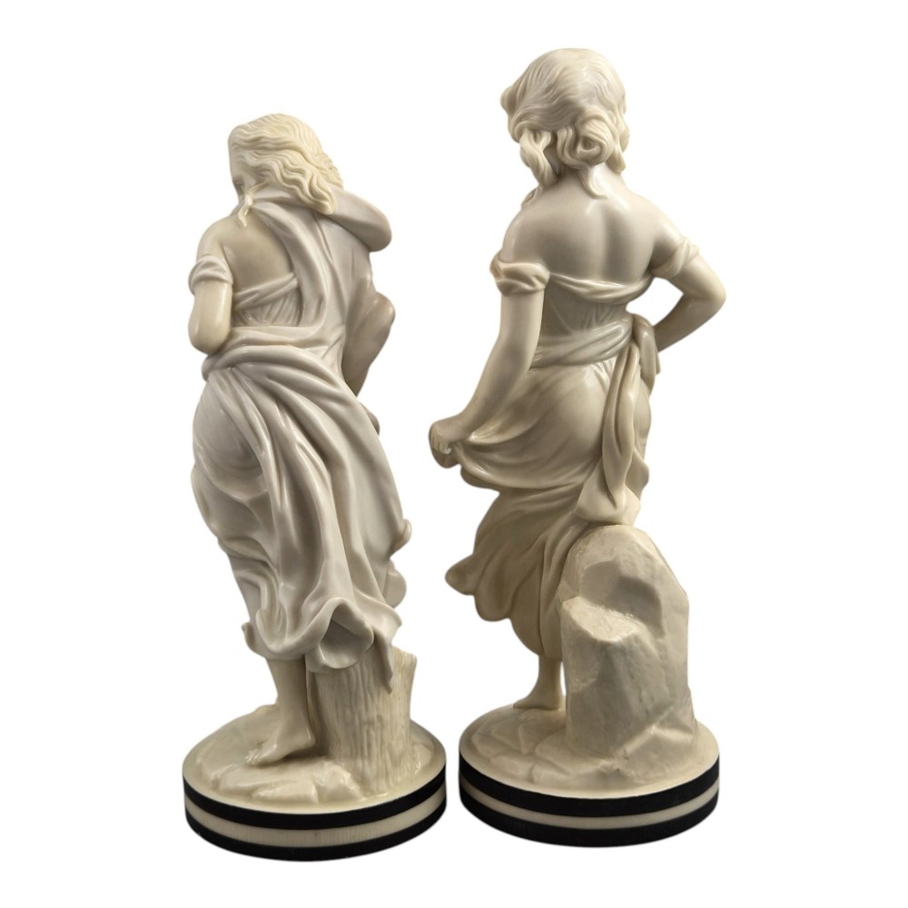 A pair of Victorian cream-glazed porcelain figures depicting classical female forms with flowing drapery set on circular bases. View III
