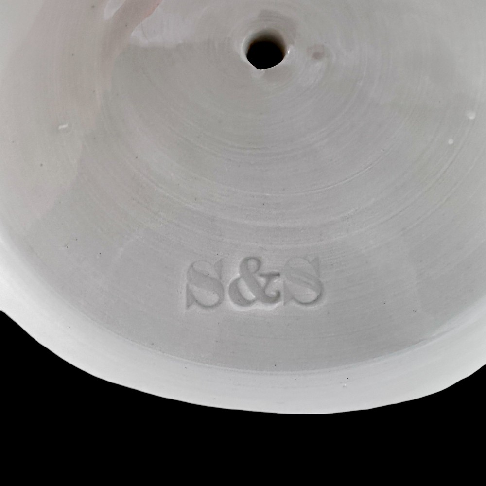 A pair of white glazed porcelain candlesticks featuring sculpted classical female figures holding urn-shaped sconces with gilt trim on circular bases. View X