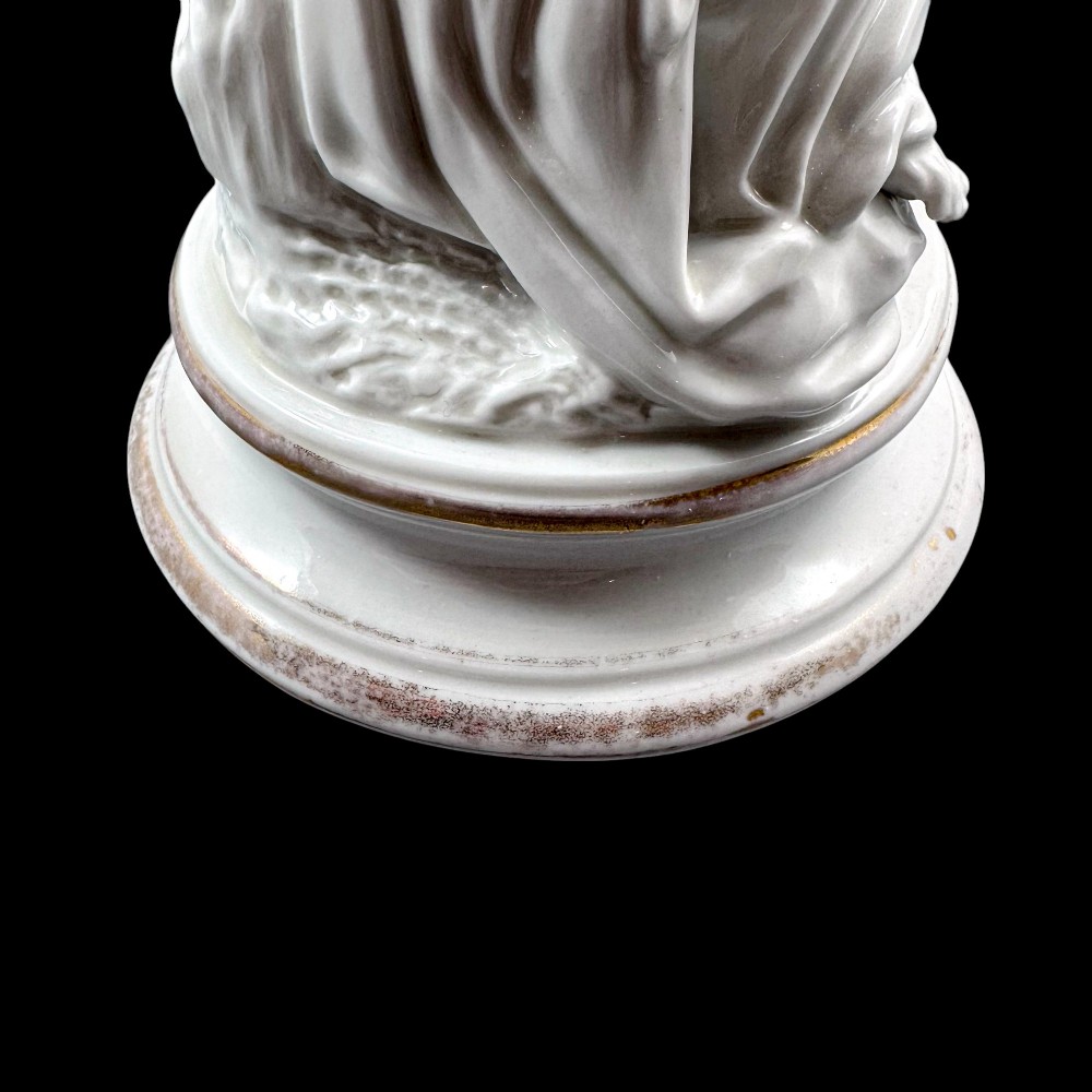 A pair of white glazed porcelain candlesticks featuring sculpted classical female figures holding urn-shaped sconces with gilt trim on circular bases. View XI