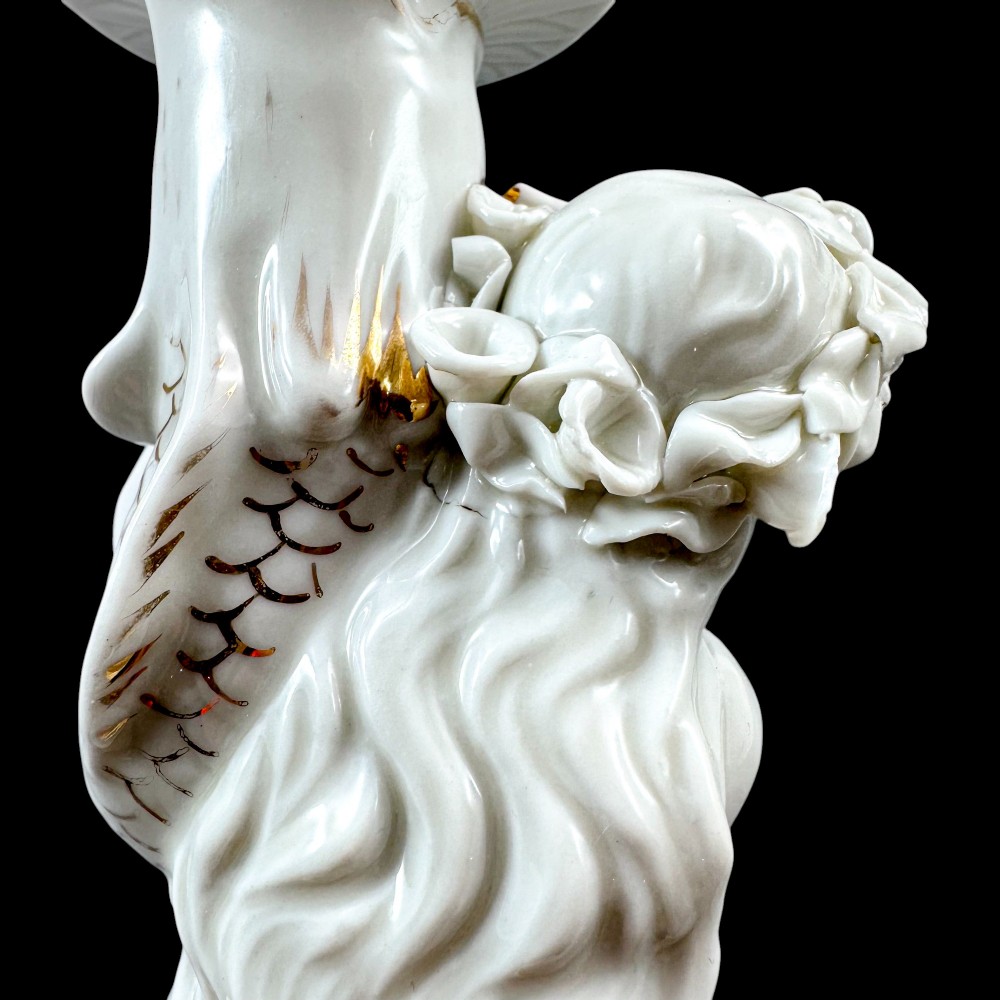 A pair of white glazed porcelain candlesticks featuring sculpted classical female figures holding urn-shaped sconces with gilt trim on circular bases. View XII