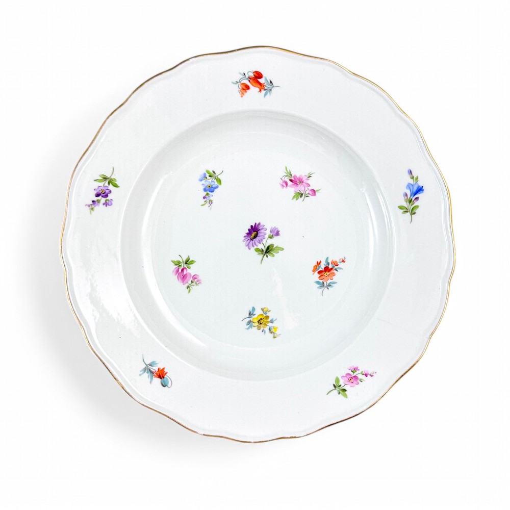 A set of three white hard-paste porcelain plates decorated with hand-painted scattered floral sprigs and scalloped gilded edges. View II