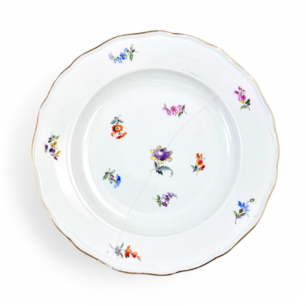 A set of three white hard-paste porcelain plates decorated with hand-painted scattered floral sprigs and scalloped gilded edges. View XI