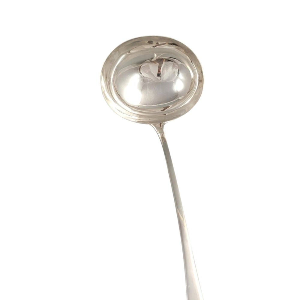 A Georgian sterling silver soup ladle featuring a deep circular bowl, a long curved stem in the Old English pattern, and an engraved crest near the handle tip. View III