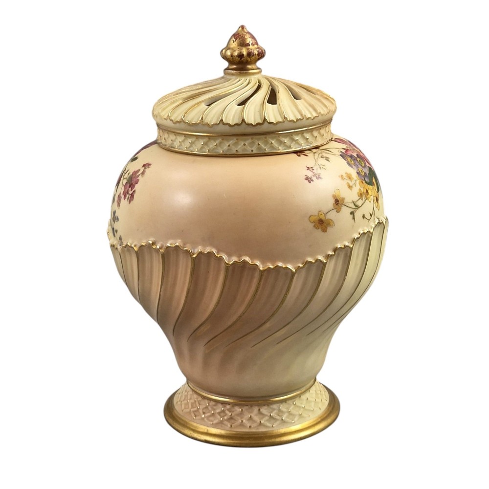 A Royal Worcester blush ivory porcelain pot-pourri jar with a pierced lid, fluted swirled lower body, gold trim, and hand-painted floral motifs. View III