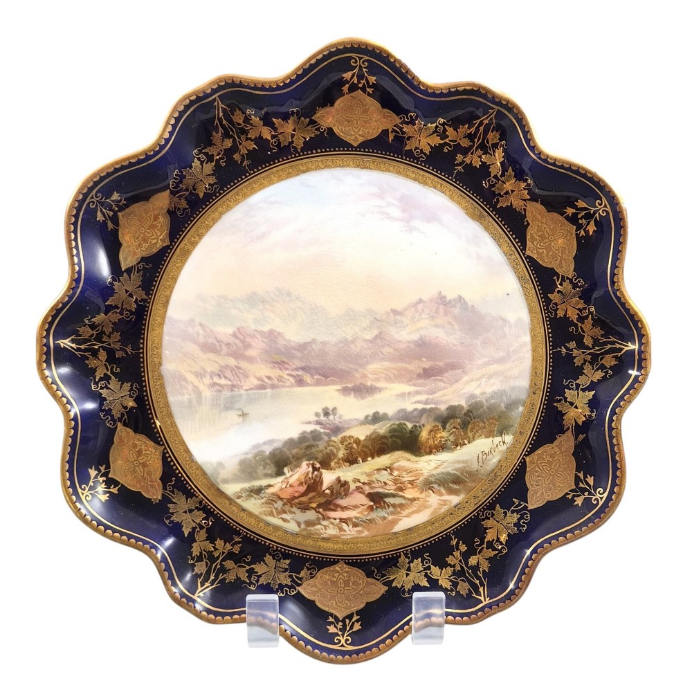 A set of four late nineteenth-century Aynsley porcelain cabinet plates featuring hand-painted landscape scenes surrounded by cobalt blue rims with heavy gold foliage gilding. View VII