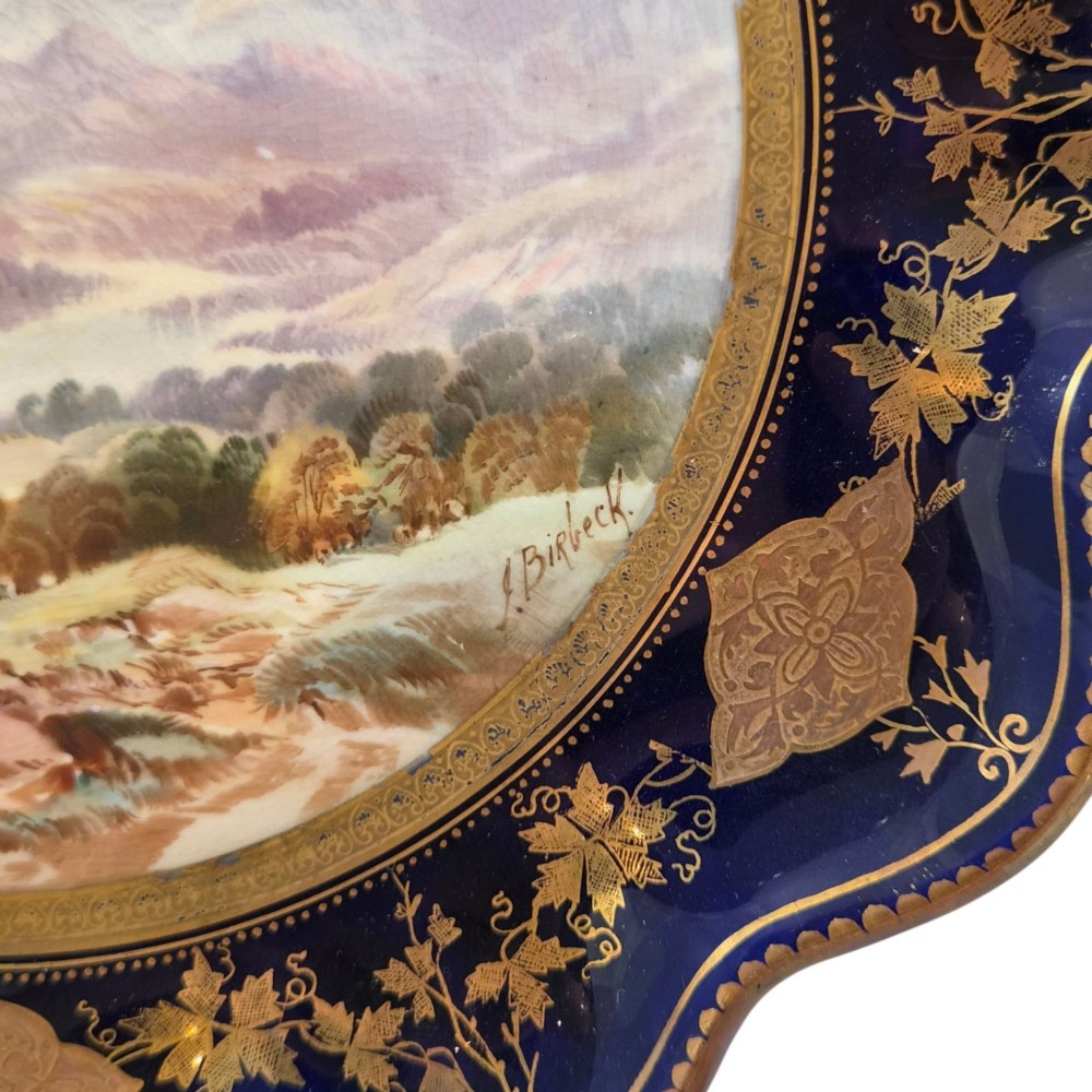 A set of four late nineteenth-century Aynsley porcelain cabinet plates featuring hand-painted landscape scenes surrounded by cobalt blue rims with heavy gold foliage gilding. View VIII