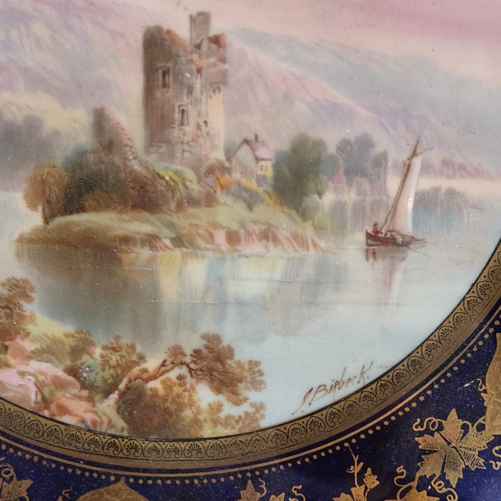 A set of four late nineteenth-century Aynsley porcelain cabinet plates featuring hand-painted landscape scenes surrounded by cobalt blue rims with heavy gold foliage gilding. View X