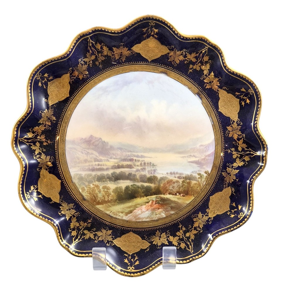 A set of four late nineteenth-century Aynsley porcelain cabinet plates featuring hand-painted landscape scenes surrounded by cobalt blue rims with heavy gold foliage gilding. View XII