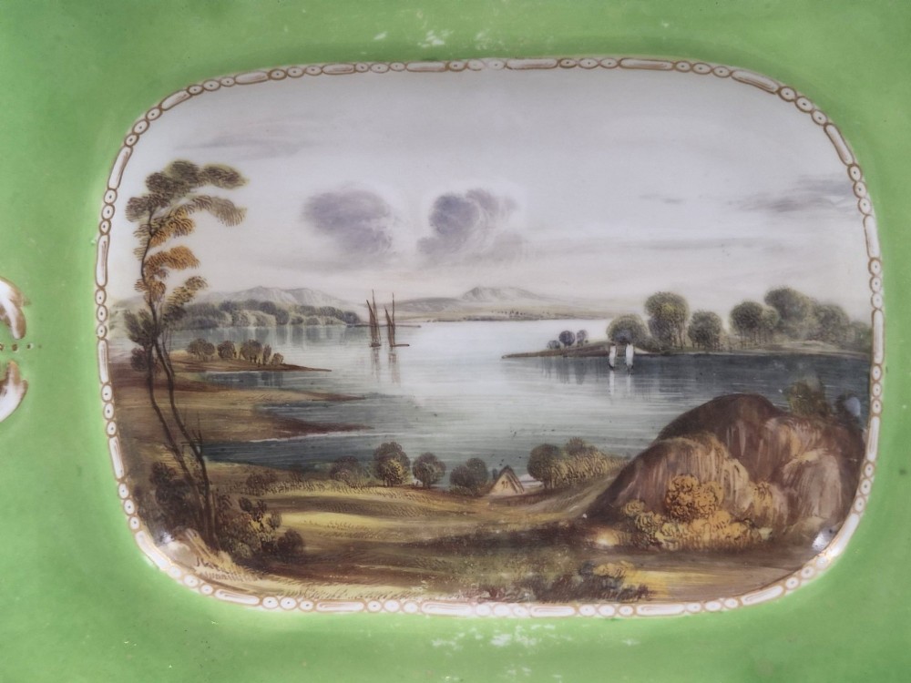 A pair of rectangular porcelain serving dishes featuring apple green borders with gilded scrollwork and central hand-painted landscape scenes. View IX
