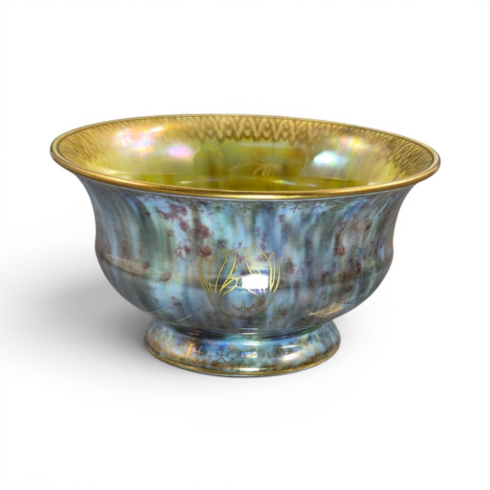 An iridescent blue footed porcelain bowl with gilded dragon motifs and a patterned gold interior rim.