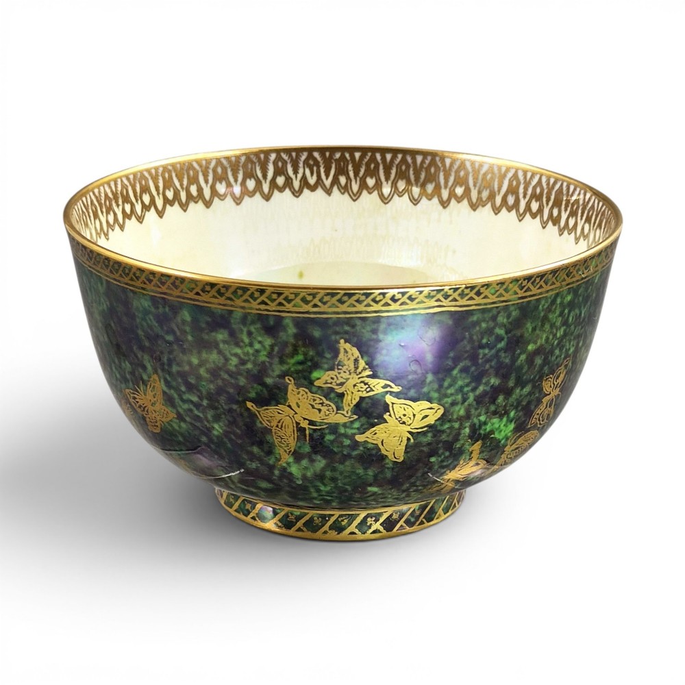 A deep porcelain bowl featuring a mottled green iridescent exterior decorated with gilded butterflies and geometric gold borders around the rim and base.