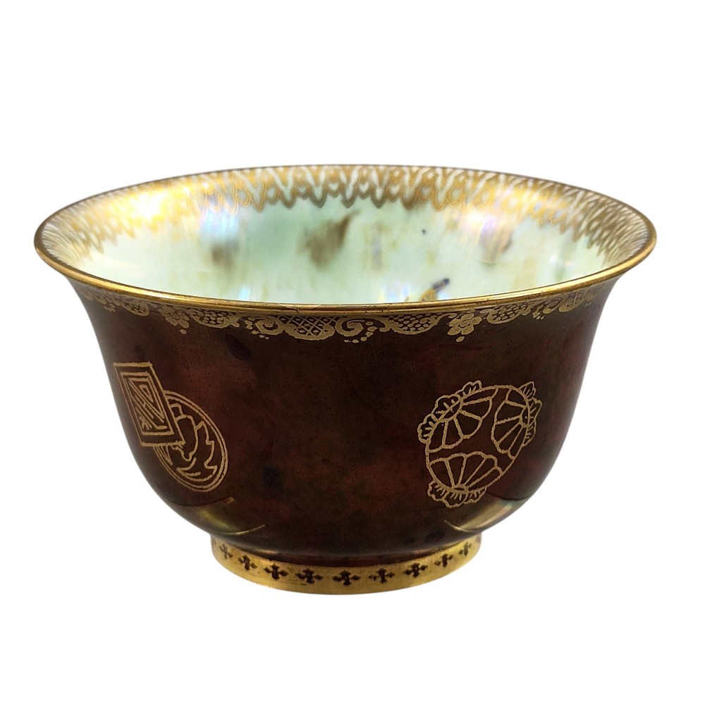 A deep red ceramic bowl with a flared rim, featuring gilded motifs on the exterior and an iridescent opalescent glazed interior. View II