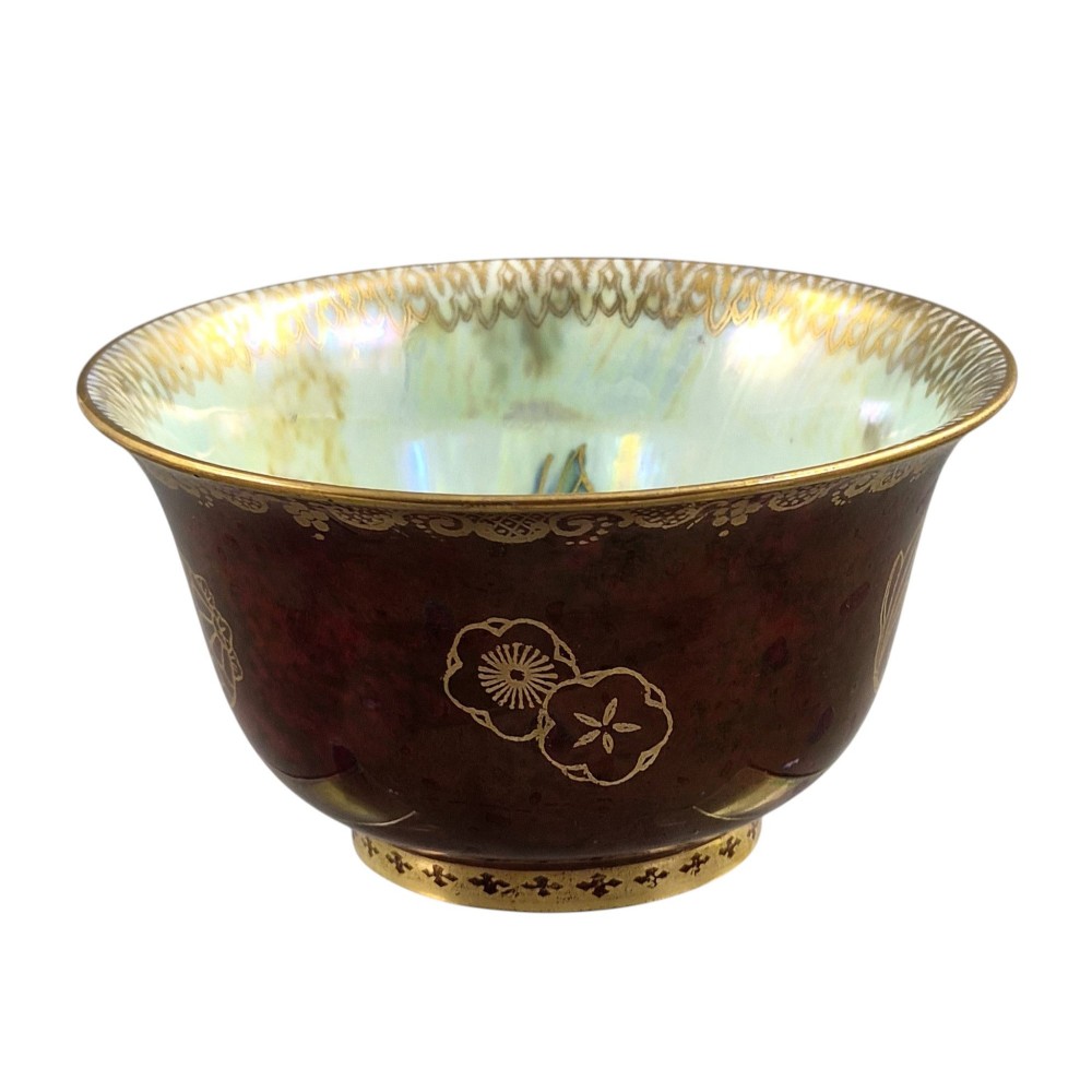 A deep red ceramic bowl with a flared rim, featuring gilded motifs on the exterior and an iridescent opalescent glazed interior. View III