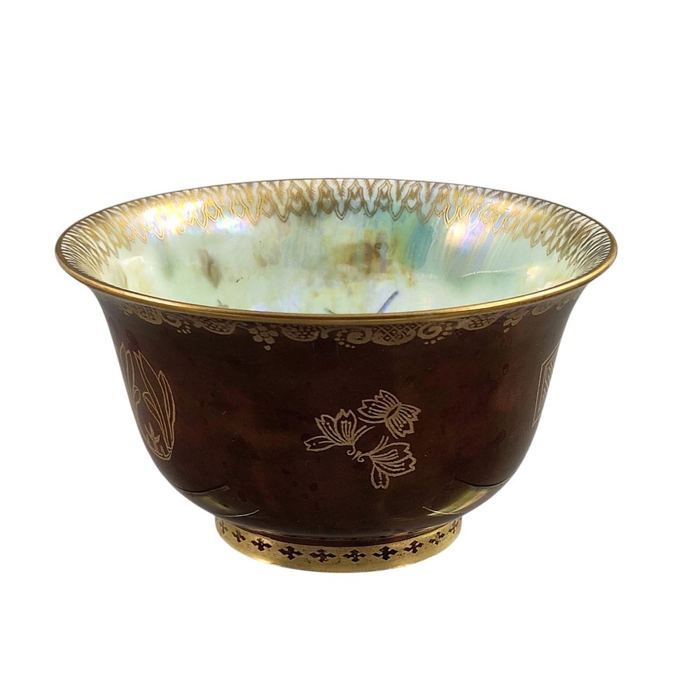 A deep red ceramic bowl with a flared rim, featuring gilded motifs on the exterior and an iridescent opalescent glazed interior. View V