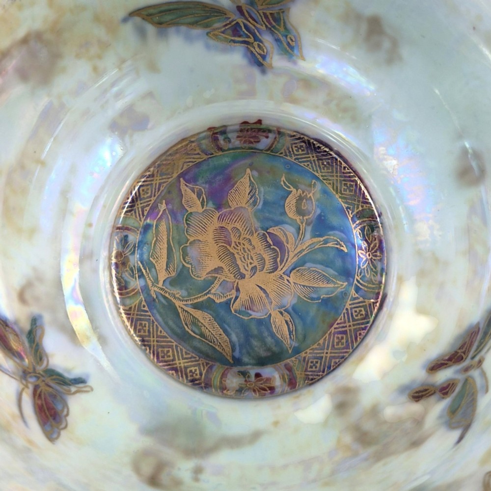 A deep red ceramic bowl with a flared rim, featuring gilded motifs on the exterior and an iridescent opalescent glazed interior. View VIII