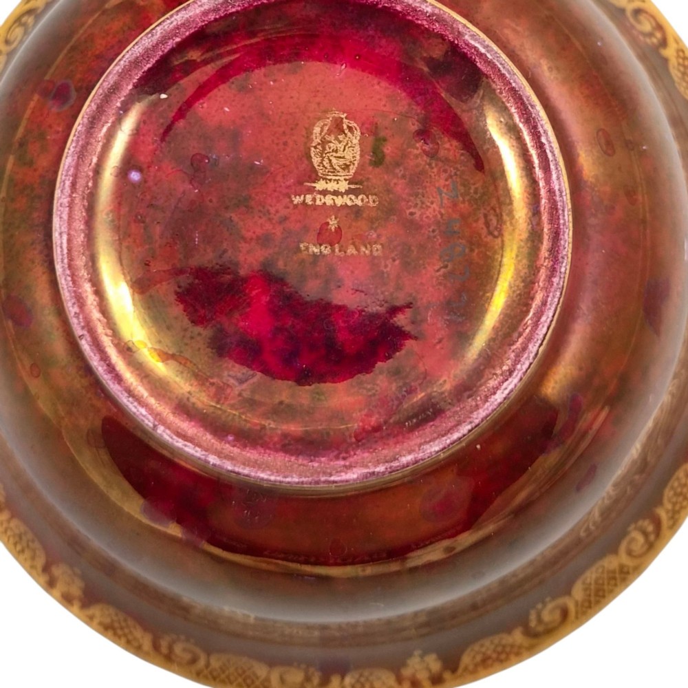 A deep red ceramic bowl with a flared rim, featuring gilded motifs on the exterior and an iridescent opalescent glazed interior. View IX