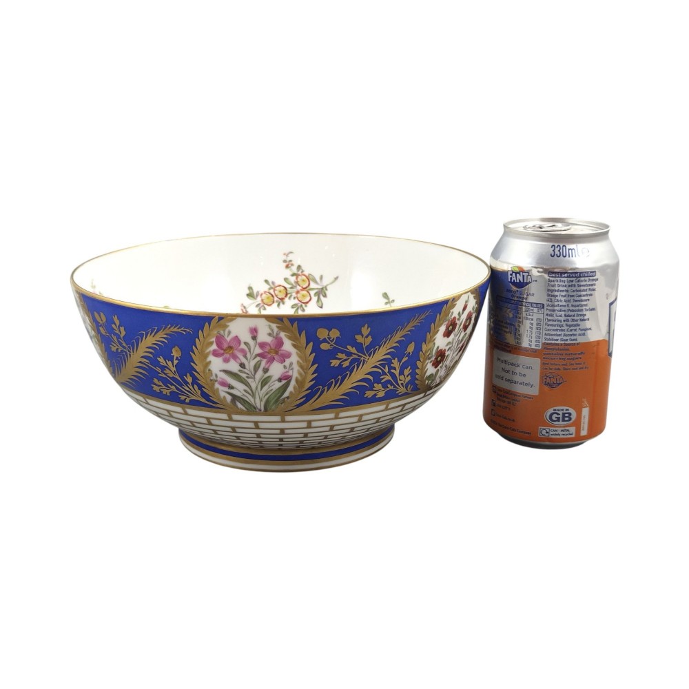 A late 19th-century Samson hard-paste porcelain footed bowl featuring a cobalt blue band with gilded leaf details, hand-painted floral cartouches, and a white brick-patterned base. View IV
